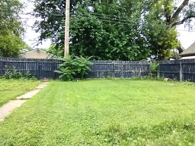 a view of a backyard with a small cabin and a chair