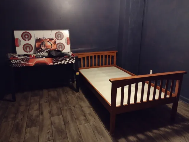 a bed sitting in a bedroom next to a wooden wall