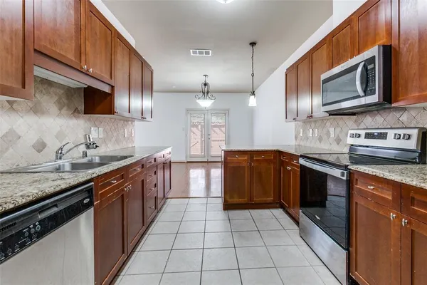 a large kitchen with stainless steel appliances granite countertop a stove microwave and sink