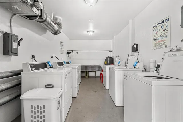 a room with a washing machine and a chair