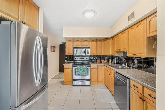 a kitchen with stainless steel appliances granite countertop a refrigerator and a stove