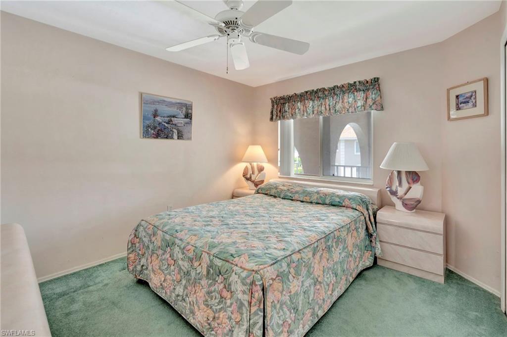 234 Pebble Beach Boulevard, Unit 305 Naples, FL 34113 - Photo 12 of 17 a bedroom with a bed and a chandelier