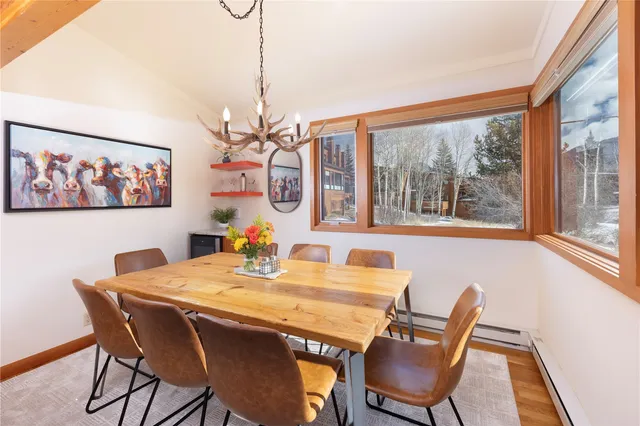 a view of a dining room with furniture a chandelier and wooden floor