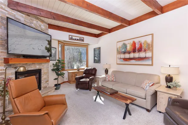 a living room with furniture a fireplace and a large window