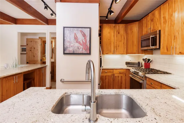 a kitchen with stainless steel appliances granite countertop a sink stove and cabinets