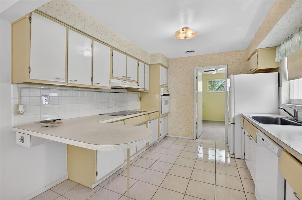 450 Northwest 12th Avenue Boca Raton, FL 33486 - Photo 16 of 58 a kitchen with granite countertop a sink a stove a refrigerator and cabinets
