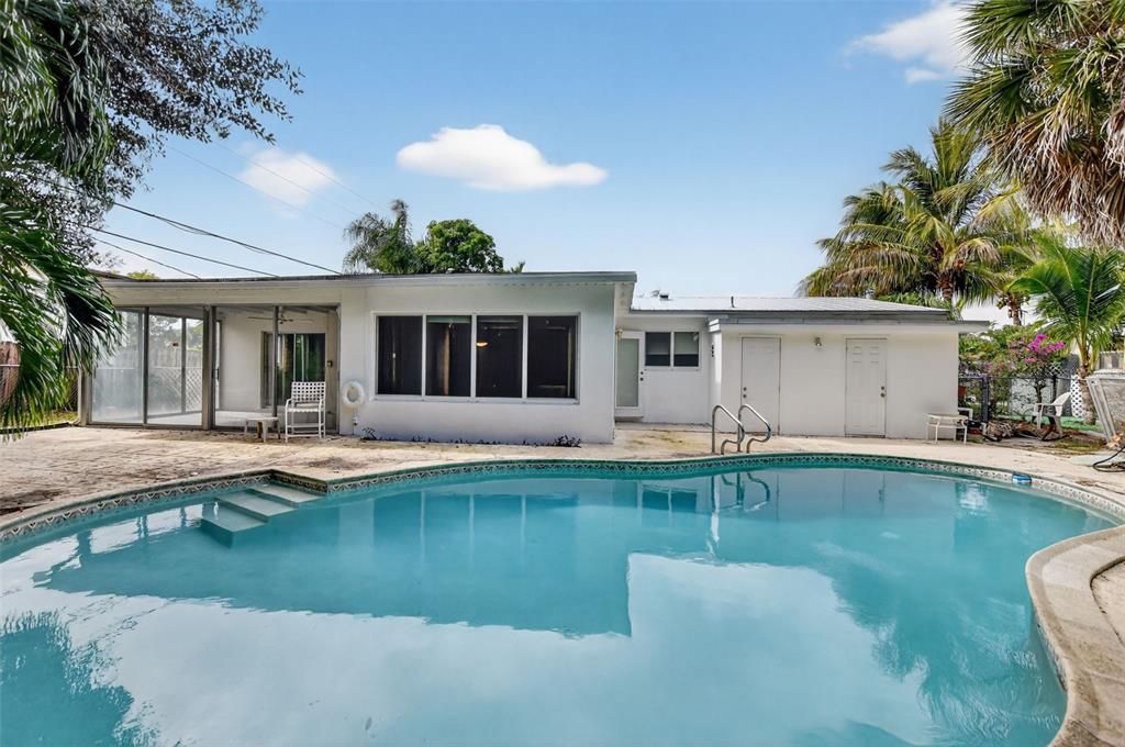 450 Northwest 12th Avenue Boca Raton, FL 33486 - Photo 38 of 58 a view of a house with swimming pool and a table and chairs
