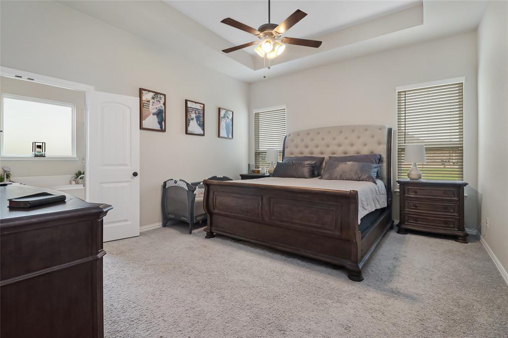189 Chester Road Springtown, TX 76082 - Photo 17 of 29 a bedroom with a bed and a chandelier