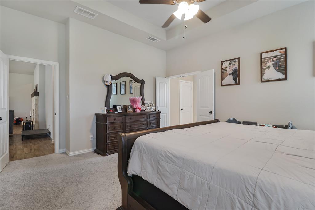 189 Chester Road Springtown, TX 76082 - Photo 18 of 29 a bedroom with a bed and a chandelier