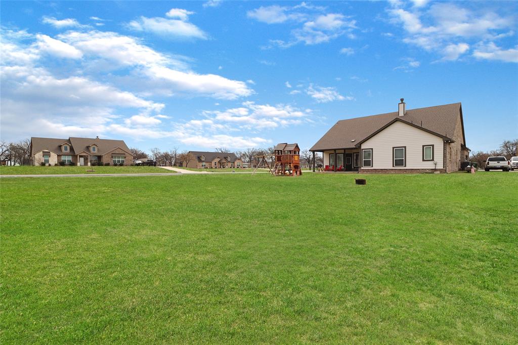 189 Chester Road Springtown, TX 76082 - Photo 27 of 29 a view of a house with a big yard and large trees