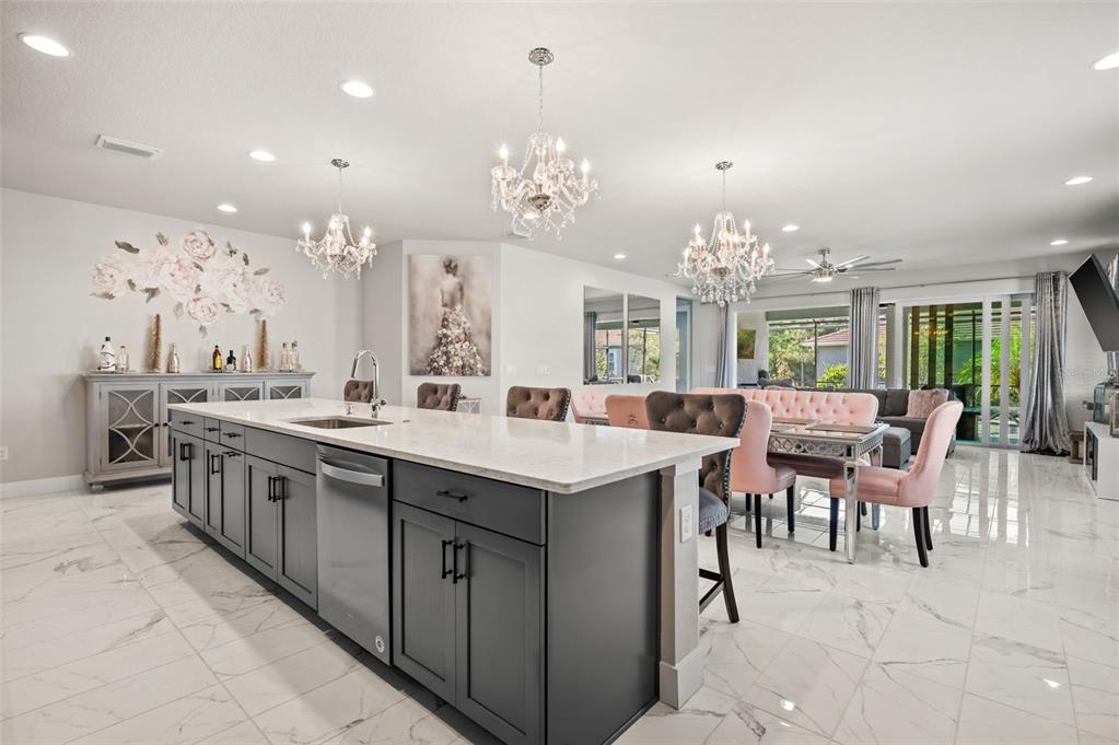 5632 Long Shore Loop Sarasota, FL 34238 - Photo 14 of 56 a large kitchen with kitchen island a sink a stove a dining table and chairs