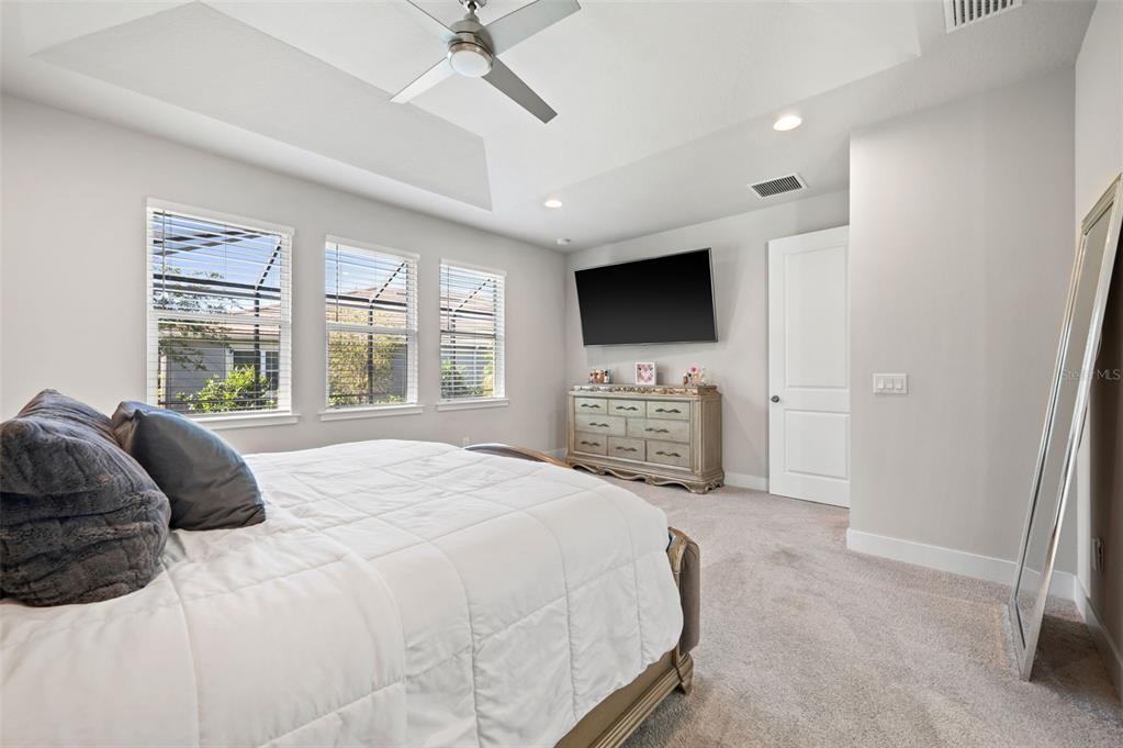 5632 Long Shore Loop Sarasota, FL 34238 - Photo 35 of 56 a spacious bedroom with a bed and a flat screen tv