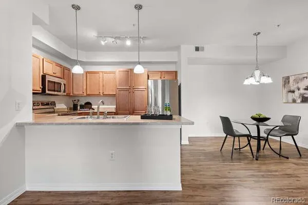 a kitchen with stainless steel appliances granite countertop a sink a stove a microwave and wooden cabinets