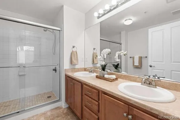a bathroom with a double vanity sink mirror and shower