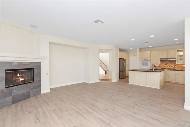 a view of kitchen with kitchen island a sink and a fireplace