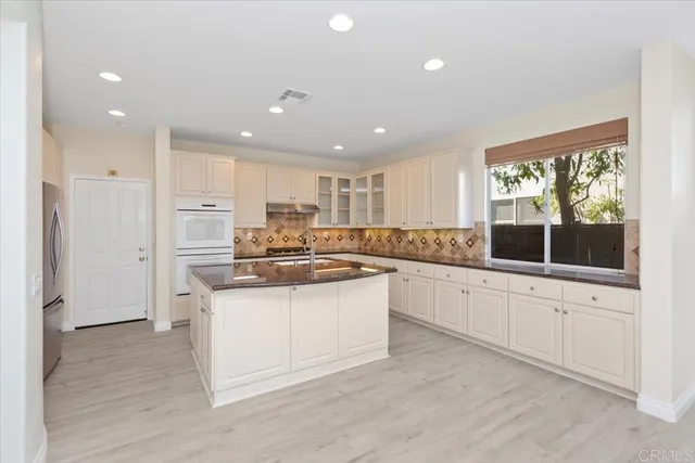 a kitchen with stainless steel appliances granite countertop a stove a sink and a refrigerator