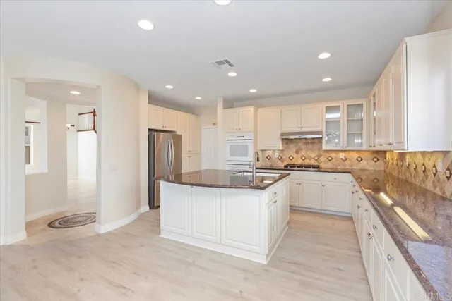 a kitchen with stainless steel appliances granite countertop a sink and cabinets