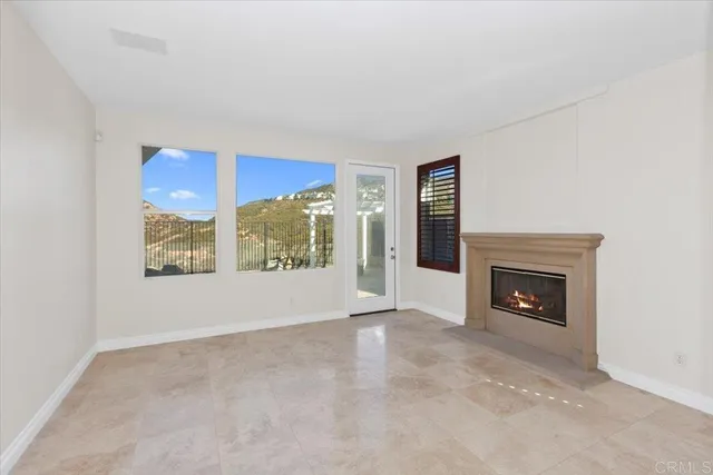a view of an empty room with a fireplace and window