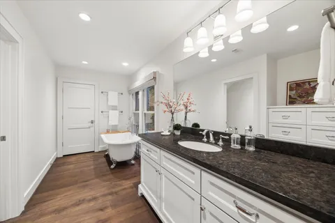 a spacious bathroom with a granite countertop sink a toilet and a mirror