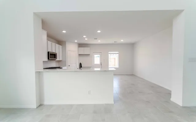 a view of kitchen with stainless steel appliances granite countertop refrigerator sink and cabinets