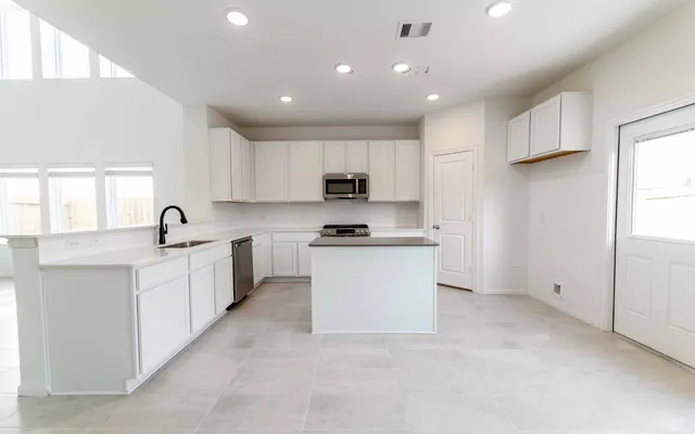 a large white kitchen with white cabinets