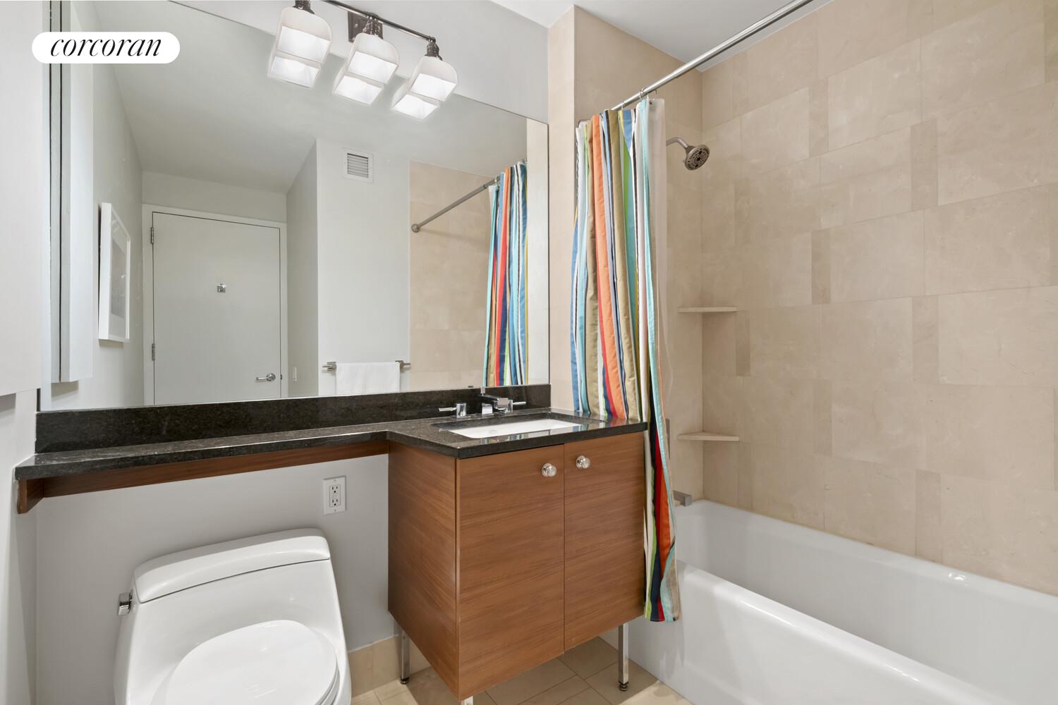 120 Riverside Boulevard, Unit PH1J Manhattan, NY 10069 - Photo 9 of 12 a bathroom with a granite countertop sink a toilet and bathtub