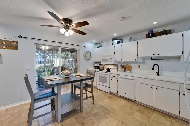 a kitchen with stainless steel appliances granite countertop a refrigerator a stove a sink a stove and white cabinets