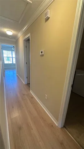 a view of a hallway with wooden floor and closet