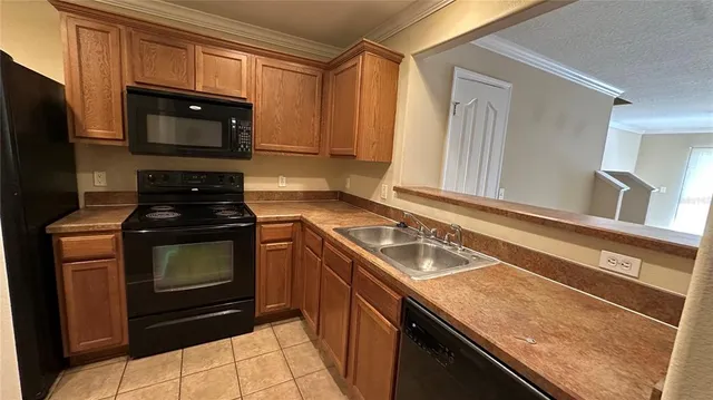 a kitchen with granite countertop a stove sink and microwave