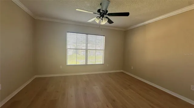 an empty room with a window and a fan