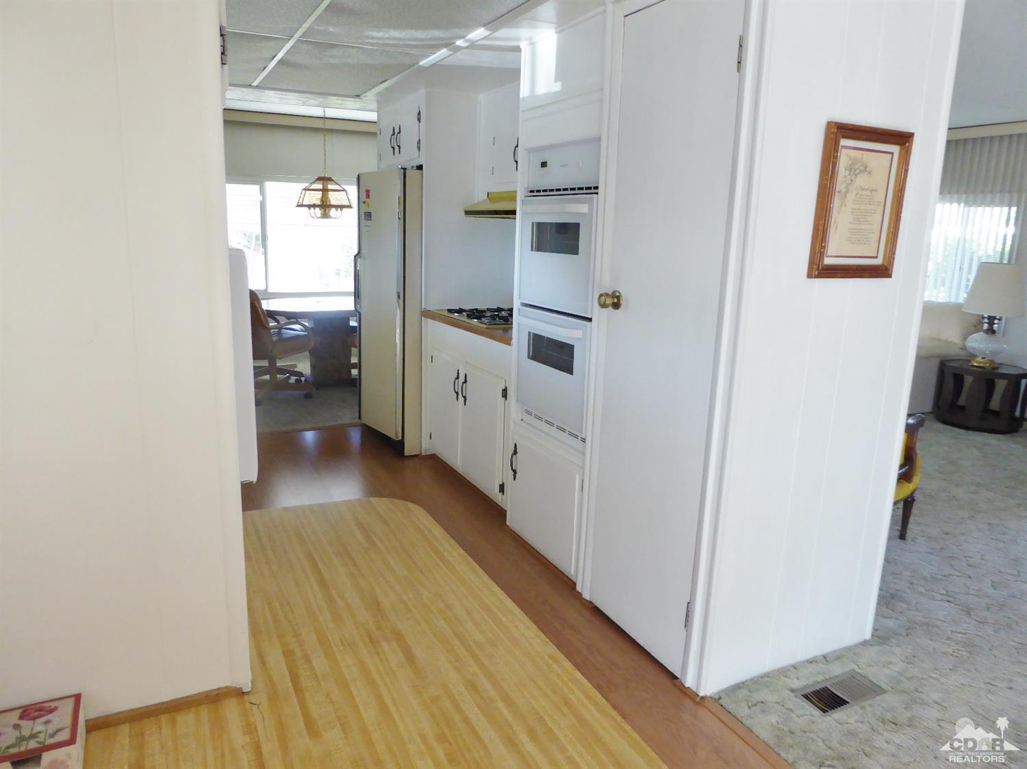 73710 Algonquin Place Thousand Palms, CA 92276 - Photo 8 of 16 a kitchen with cabinets and wooden floor