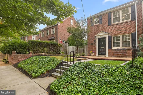 a view of a house with a small yard and potted plants
