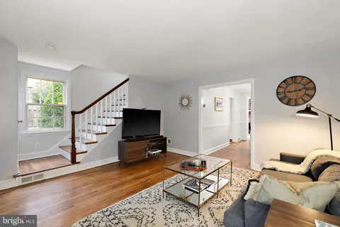 a living room with furniture a rug and a flat screen tv