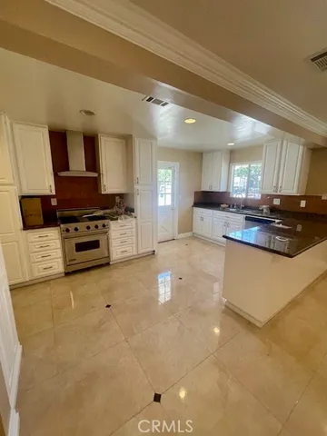 a kitchen with stainless steel appliances granite countertop a stove a sink and a microwave