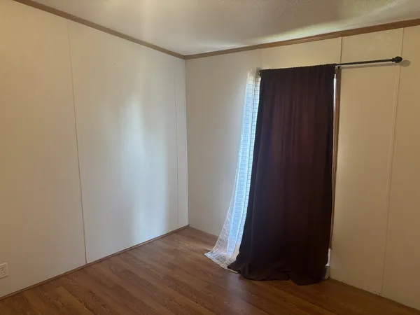 a view of an empty room with wooden floor