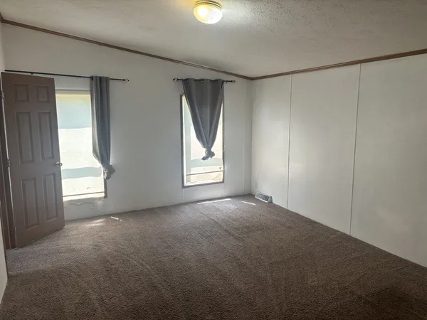 an empty room with windows and closet