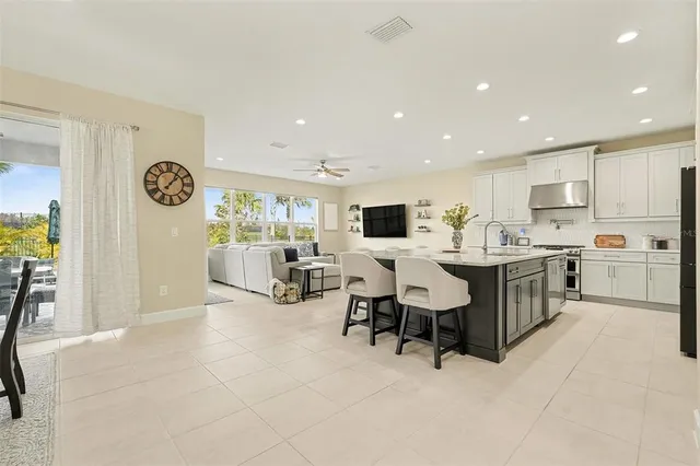 a large white kitchen with a large window and stainless steel appliances