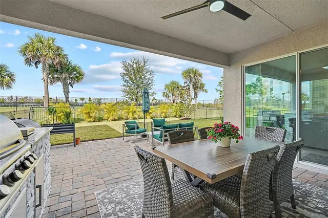 a view of a swimming pool with lawn chairs and a big yard