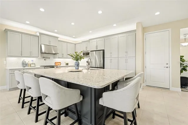 a kitchen with granite countertop a table chairs stove and microwave