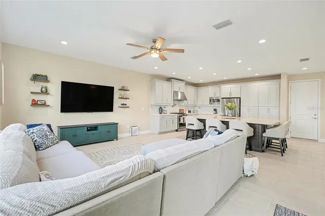 a living room with furniture kitchen view and a flat screen tv