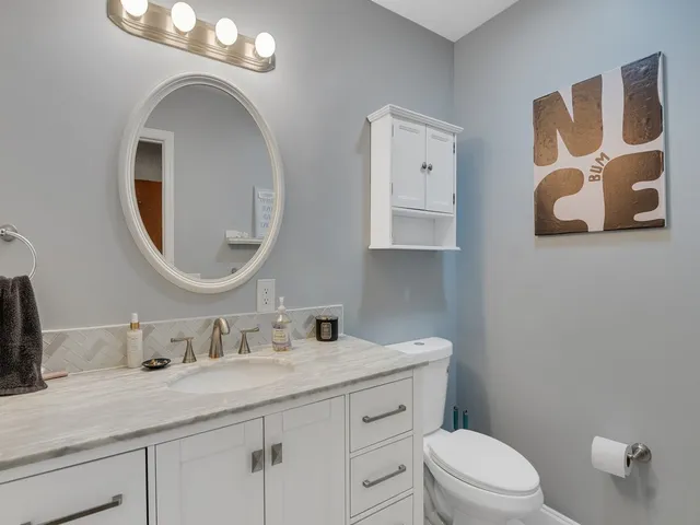 a bathroom with a granite countertop sink a mirror and shower