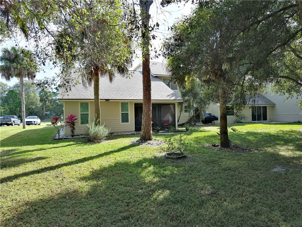 2020 Vero S Circle Southwest, Unit 4 Vero Beach, FL 32962 - Photo 22 of 28 a front view of a house with a yard and trees