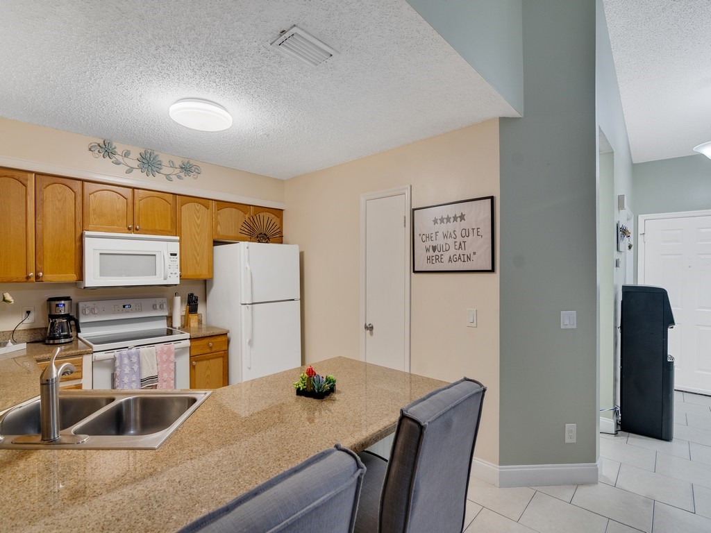 2020 Vero S Circle Southwest, Unit 4 Vero Beach, FL 32962 - Photo 8 of 28 a kitchen with stainless steel appliances granite countertop a sink refrigerator and microwave