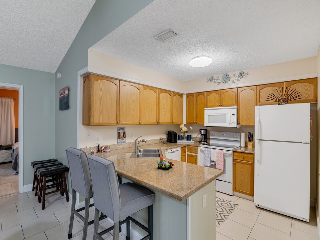 2020 Vero S Circle Southwest, Unit 4 Vero Beach, FL 32962 - Photo 9 of 28 a kitchen with a sink a stove a refrigerator and white cabinets