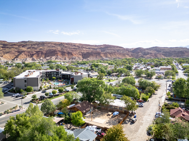 186 West Center Street Moab, UT 84532 - Photo 14 of 15 Expansive aerial perspective showcasing a town with varied architecture and mature trees, set against a backdrop of red rock formations