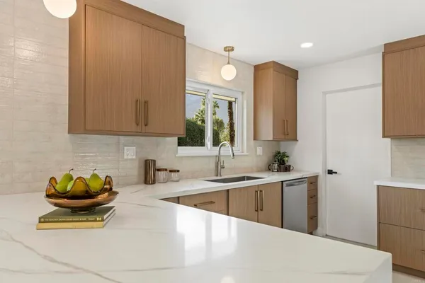a kitchen with stainless steel appliances a sink a stove and cabinets