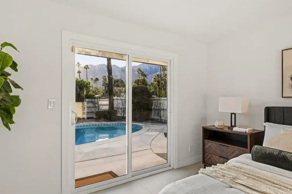 a bedroom with a bed and glass door