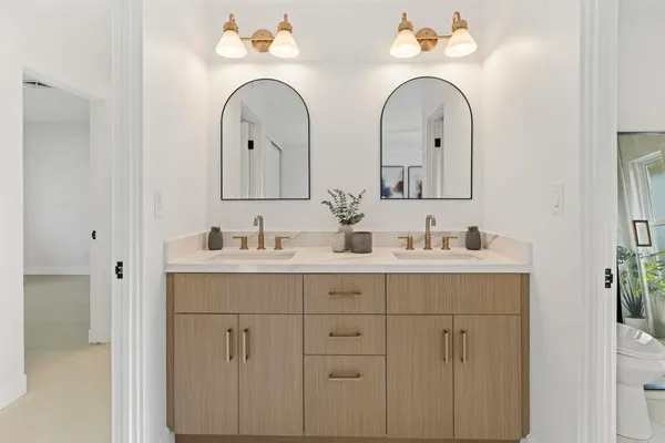 a bathroom with double vanity sinks and a mirror