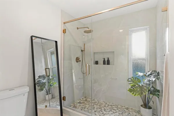 a bathroom with a shower a mirror and a shower