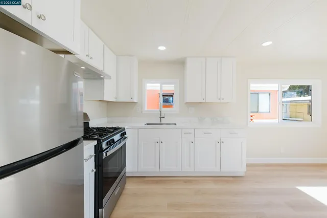 a kitchen with white cabinets and appliances